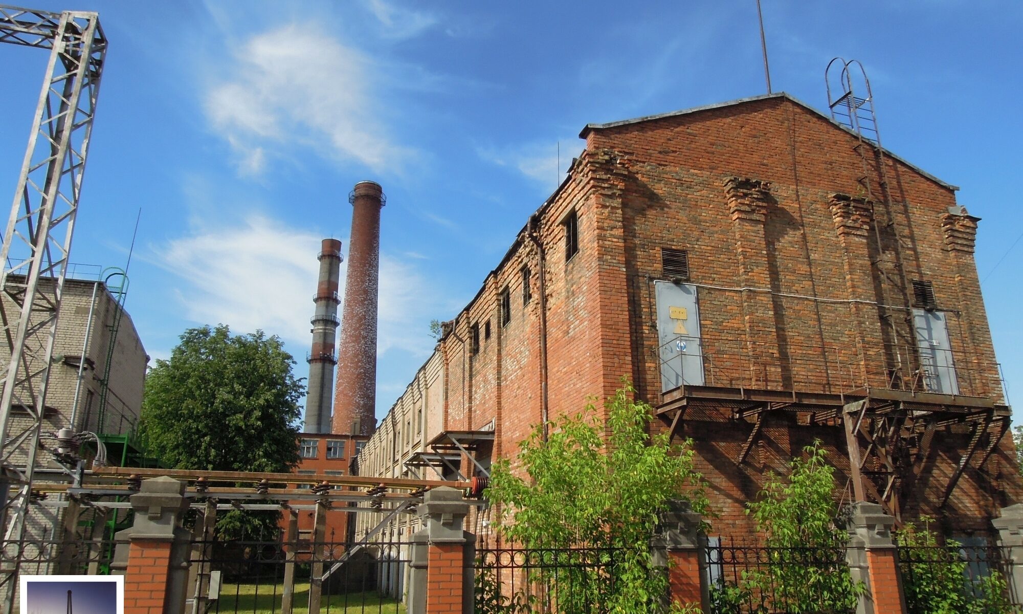 Foto eines Kraftwerks auf der Halbinsel Andrejsala in Riga, Lettland, historische Backstein-Bausubstanz, Außenansicht Fabrikshalle mit zwei Schloten